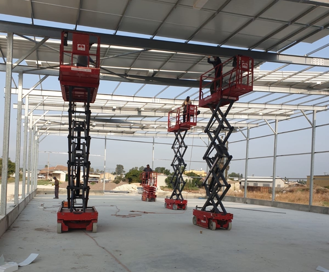 פיגומים ניידים אדומים מיועדים לעובדים בבניין שנמצא בבנייה.